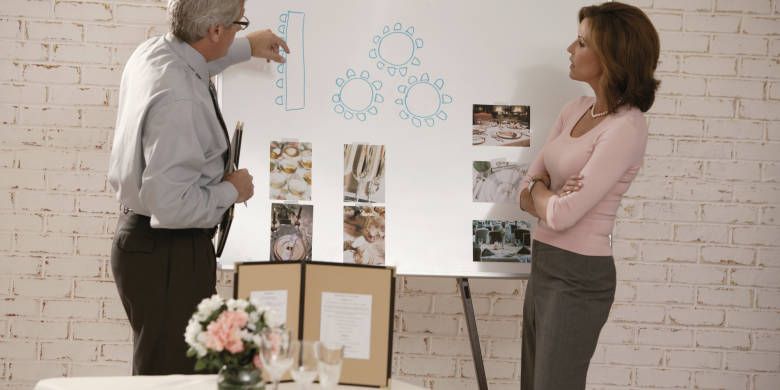 Woman looking at seating arrangements with wedding planner